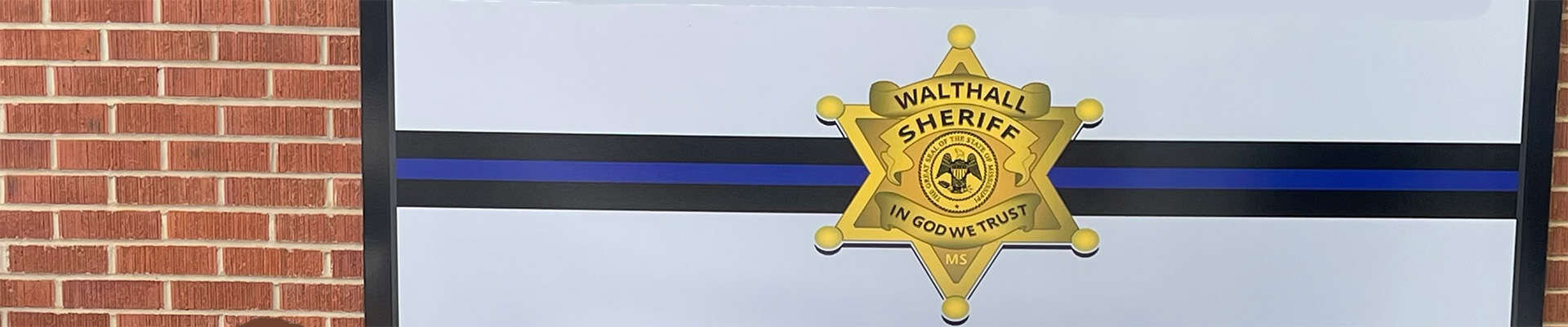 Walthall County Sheriff's Department logo on a brick wall.